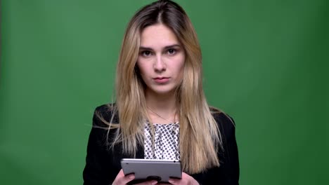 Closeup-shoot-of-young-attractive-hipster-caucasian-female-using-the-tablet-and-looking-at-camera-with-background-isolated-on-green