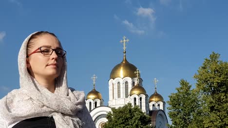 Mujer-de-estilo-de-vida-ortodoxa-en-una-bufanda-se-encuentra-en-el-fondo-de-la-Iglesia-Ortodoxa