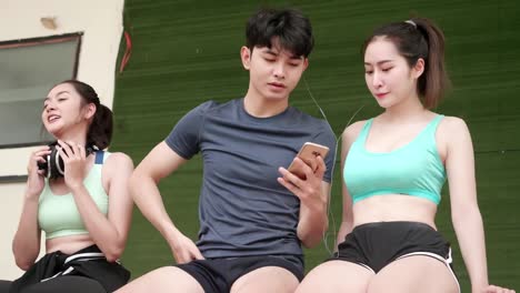 Asian-young-men-and-girl-relexing-exercise-after-sport-running