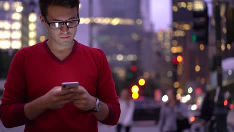 Cheerful-male-teenager-in-eyeglasses-enjoying-smartphone-communication-with-best-friend-during-time-for-walking-outdoors