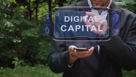 Businessman-uses-hologram-with-text-Digital-capital