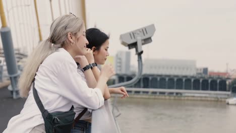 Asian-lesbian-couples-enjoying-traveling-and-talk-while-standing-on-the-bridge.-LGBT-concept.