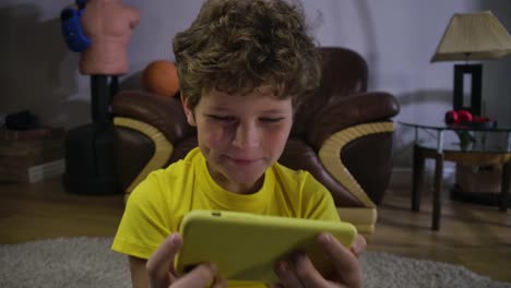 Nahaufnahme-Gesicht-des-kaukasischen-lockigen-Jungen-beobachten-Comedy-Show-auf-dem-Smartphone-Bildschirm.-Fröhliches-Kind-lacht.-Generation-Z,-Social-Media,-Internet,-moderne-Technologien.-Kino-4k-ProRes-HQ.