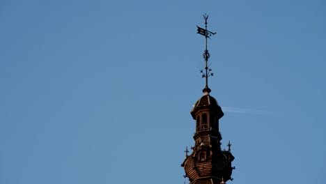 Spitze-des-alten-Gebäudes-und-fliegendes-Flugzeug-in-der-blauen-Luft-in-Brüssel-in-slo-mo