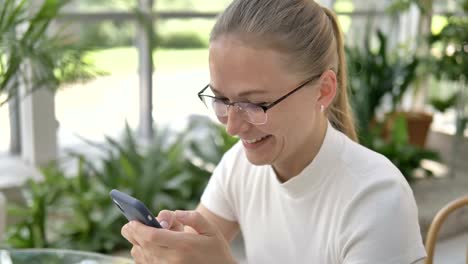 businesswoman-with-glasses-surfs-internet-in-smartphone