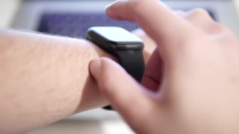 Männliche-Programmierer-testet-App,-startet-Skript-Programm-auf-Smartwatch-mit-Touchscreen