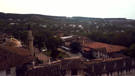 Aerial-view-on-the-old-city-with-church-before-sunset,-sunrise.-Fog,-Cloudy-sky.-Bahchisarai,-Crimea,-Russia.