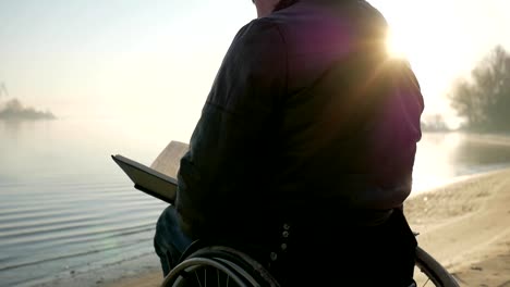 Disabled-man-in-wheelchair-reads-bible,-faith-in-god,-faith-in-future