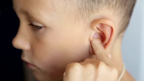 The-boy's-finger-massages-the-left-ear