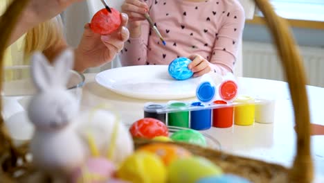 ¡Feliz-Pascua-de-resurrección!-Madre-y-su-pequeña-hija-con-divertidas-orejas-de-conejo-para-colorear-huevos-de-Pascua