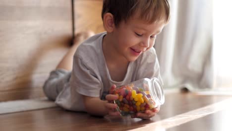 Jungen-spielen-mit-Glas-mit-Süßigkeiten