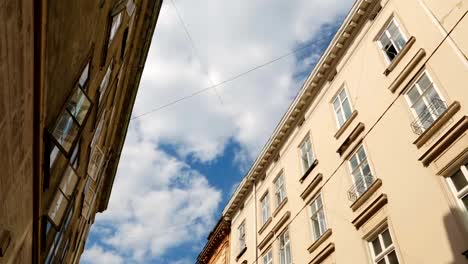 Blue-sky-with-white-running-clouds-between-ancient-architecture,-time-lapse