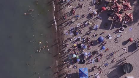 Aerial-view-maritime-city-on-Black-sea.-Seashore-and-vacationers-people-on-the-beach,-beach-umbrellas