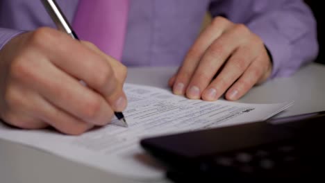 Man-filling-US-tax-form.-tax-form-us-business-income-office-hand-fill-concept.-Closeup.--Man-Is-Checking-The-Box-Of-Filing-Status-In-The-US-Individual-Income.--Tax-Return-Form-1040