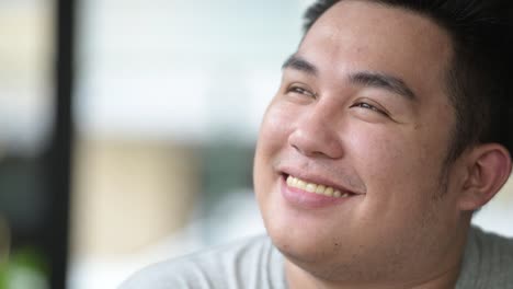 Young-handsome-overweight-Asian-man-relaxing-at-the-coffee-shop