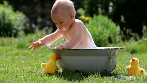 Niño-lindo,-jugando-con-little-bunny-y-Pascua-huevos-en-una-primavera-floreciente-jardín.-Niño-juega-con-el-conejo,-caza-para-vacaciones-del-huevo