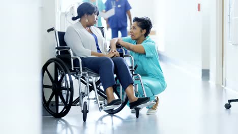 Personal-femenino-afroamericano-y-paciente-en-silla-de-ruedas