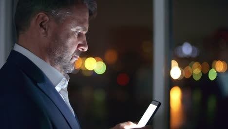 Businessman-Typing-a-Message-on-Smartphone-in-the-Night