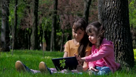 Los-niños-en-la-naturaleza-juegan-en-la-tableta.