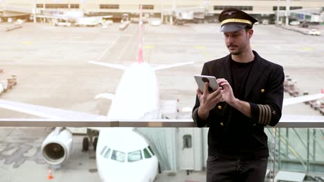 Young-Caucasian-pilot-checking-data-on-tablet-before-takeoff