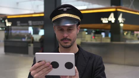 Young-Caucasian-pilot-checking-data-on-tablet-before-takeoff