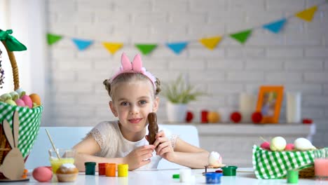 Kleines-Mädchen-in-süße-Stirnband-Lächeln-und-posieren-auf-Kamera-mit-Schokohase