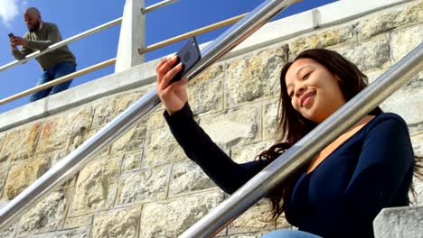 Woman-taking-selfie-with-mobile-phone-on-stairs-4k