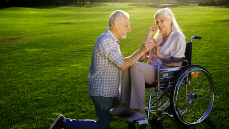 Senior-hombre-mujer-propone-rodilla-en-silla-de-ruedas