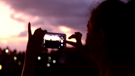 Frau-nehmen-Foto-mit-Sonnenuntergang-Himmel