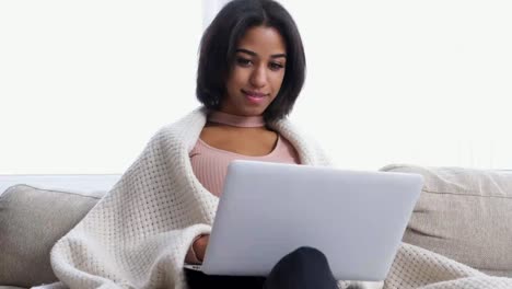 Teenage-girl-using-laptop-on-sofa