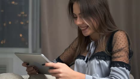 Happy-woman-using-digital-tablet-on-sofa