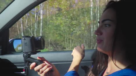 Beautiful-young-brunette-woman-in-a-car-shooting-video-for-her-blog-with-camera