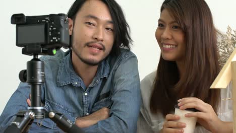 asian-couple-blogger-love-on-social-media-with-good-story-to-camera-home-background