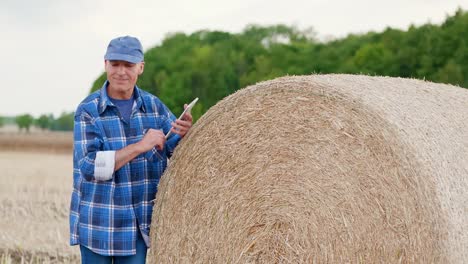 Moderne-Landwirtschaft.-Die-Liebe-zur-Landwirtschaft.-Landwirt-mit-digitalem-Tablet-bei-der-Prüfung-von-Bauernhof