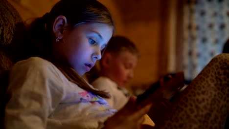 4K-two-children-sitting-immersed-in-electronic-gadgets