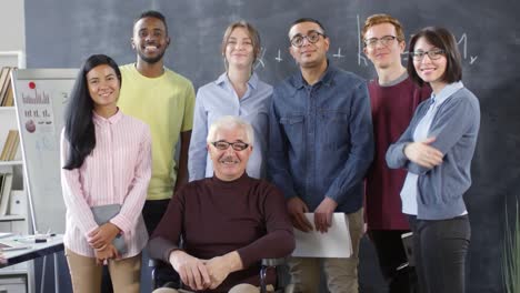 Portrait-of-Smiling-Professor-in-Wheelchair-and-Students