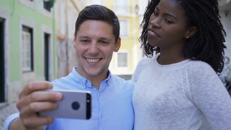 Frontansicht-von-fröhlichem-junges-Paar,-das-Selfie-mit-Smartphone-nimmt.