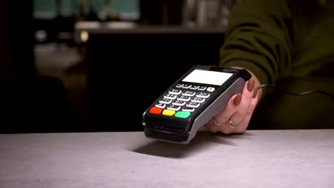 Close-up-shot-of-person-using-terminal-and-credit-card-performs-contactless-payment-and-prints-the-check.