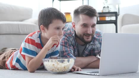 Vater-mit-Sohn-hat-Spaß-beim-Anschauen-von-Film-auf-dem-Laptop