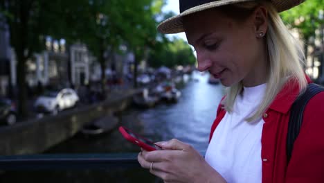 Smiling-female-tourist-in-hat-enjoying-trip-to-Amsterdam-during-summer-vacations