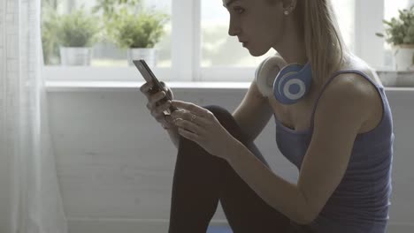 Mujer-deportiva-charlando-con-su-teléfono-móvil