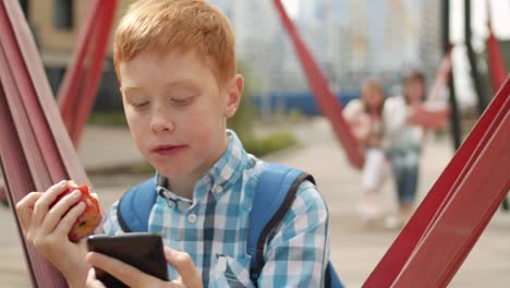 Portrait-of-Schoolboy-Eating-Fruit-Outdoors