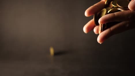 Hand-holding-a-big-heap-of-coins-and-throwing-them-on-table