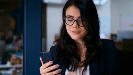 Porträt-der-schönen-jungen-Frau-mit-Smartphone-im-Büro.-Business-Lady-in-formalen-tragen-Kleid-Typing-Nachrichten-auf-ihrem-Handy.