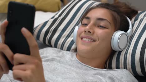 Young-Woman-Using-Phone-in-Bed