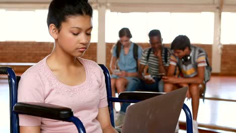 Disabled-schoolgirl-using-digital-tablet-with-classmates-in-background