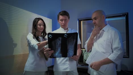 Three-doctors-look-at-an-x-ray-photo-of-a-patient-together