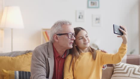 Kaukasisches-Mädchen-und-Opa-machen-Selfies-auf-dem-Smartphone