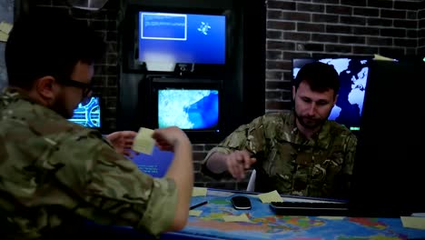 Two-serious-soldiers-in-uniform,-War-center,-monitoring-room,-working-for-laptop,-search-safety-system