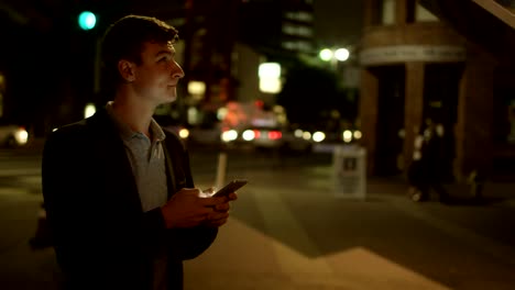 Young-attractive-man-is-texting-on-a-street